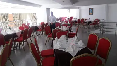 a man standing in a room with tables and chairs at Hotel Arena Fes in Fès