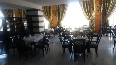 a restaurant with tables and chairs in a room at Hotel Arena Fes in Fès