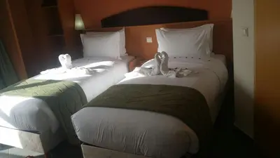 two beds in a hotel room with stuffed animals on them at Hotel Arena Fes in Fès