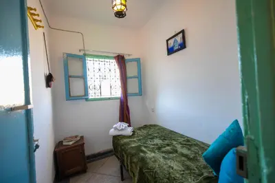 a bedroom with a green bed and a window at BackHome Fez in Fès