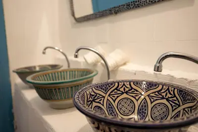 a bathroom with three sinks on a counter at BackHome Fez in Fès