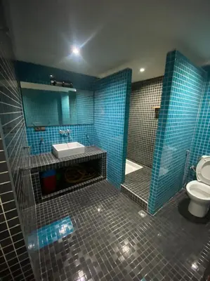 a bathroom with a sink and a toilet and blue tiles at Appartement en plein centre ville in Fès