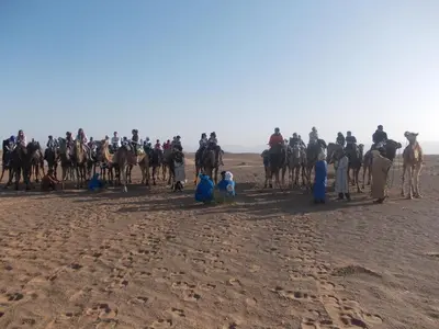 a group of people riding horses in the desert at Bivouac Draa in Zagora