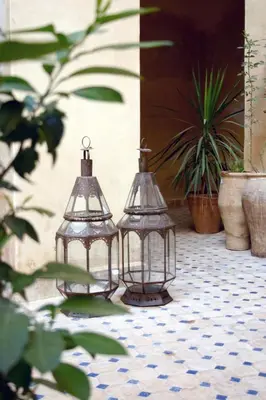 two lanterns sitting on a tile floor in a courtyard at Dar Seffarine in Fès