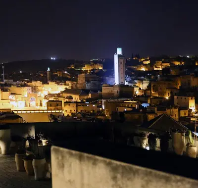 a view of a city at night at Dar Seffarine in Fès