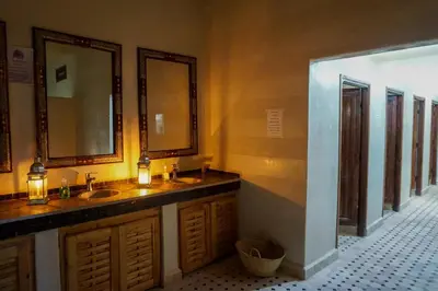 a bathroom with two sinks and two mirrors at Royal Sands Camp - Erg Chigaga Luxury Camp in Mhamid