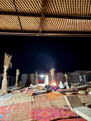 a large room with people laying on couches and a table at Royal Sands Camp - Erg Chigaga Luxury Camp in Mhamid