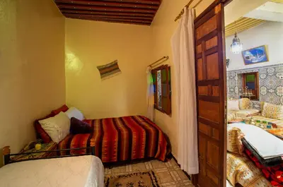 a small bedroom with two beds and a bathroom at Dar Najia in Fès