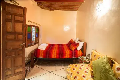 a bedroom with a bed and a door and a couch at Dar Najia in Fès