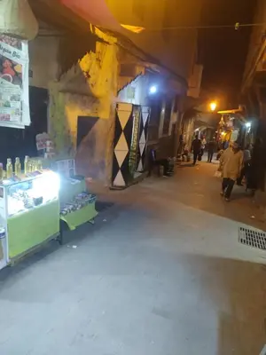 an empty street at night with people walking around at Dar Najia in Fès