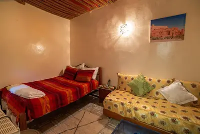 a small bedroom with a bed and a couch at Dar Najia in Fès