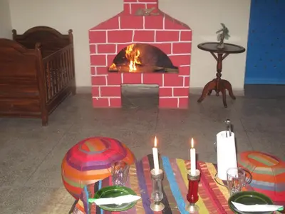 a brick fireplace in a living room with candles on a table at Gite Kasbah La Palmeraie in Skoura