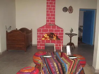 a red brick fireplace in a room with a table at Gite Kasbah La Palmeraie in Skoura
