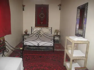 a room with a bed and two mirrors at Gite Kasbah La Palmeraie in Skoura