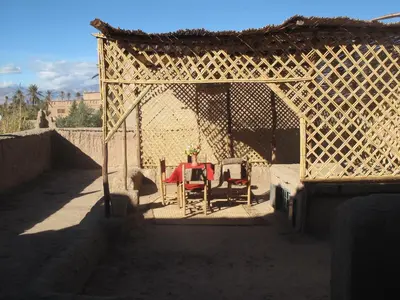 a table and chairs sitting under a pergola at Gite Kasbah La Palmeraie in Skoura