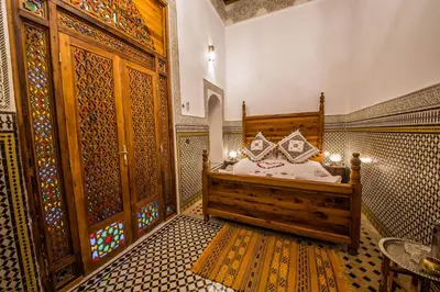 a bedroom with a bed in a room with patterns on the walls at Riad Ouliya in Fès