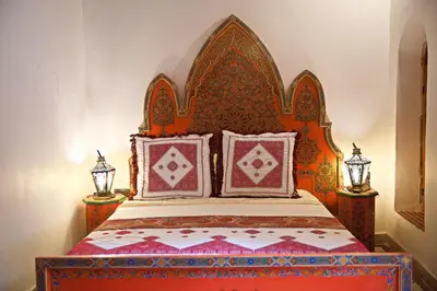 a bedroom with a bed with an ornate headboard at Riad Ouliya in Fès