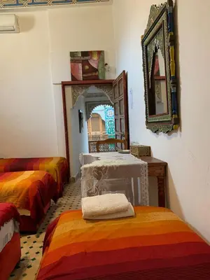 a room with two beds and a mirror on the wall at Riad Ouliya in Fès