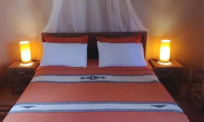 a bedroom with a bed with two lamps on both sides at Dar Jnane - La Maison Du Jardin in Agdz