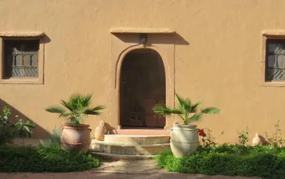 a entrance to a building with two large potted plants at Dar Jnane - La Maison Du Jardin in Agdz