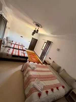 a bedroom with two beds and a laptop in it at Auberge Ksar Ait Ben Haddou in Aït Ben Haddou