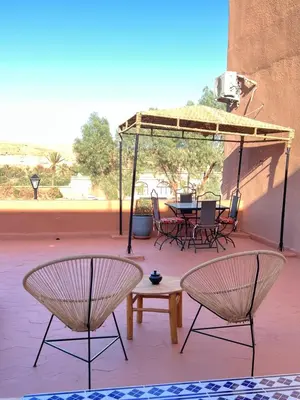 a patio with two chairs and a table and a table and chairs at Auberge Ksar Ait Ben Haddou in Aït Ben Haddou