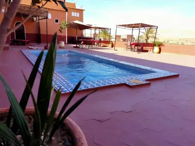 a swimming pool in front of a house with the beach at Auberge Ksar Ait Ben Haddou in Aït Ben Haddou