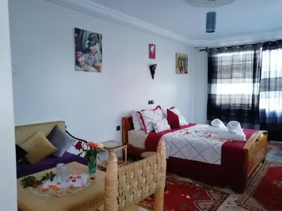 a living room with two beds and a couch at RIAD Camping ATLAS in Tinerhir