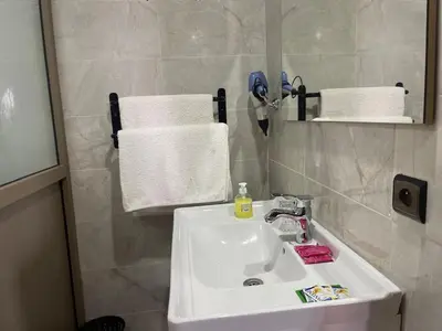 a bathroom with a sink and a mirror and towels at RIAD Camping ATLAS in Tinerhir
