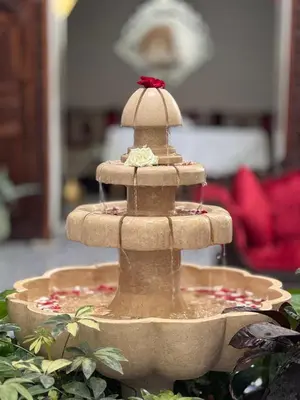 a stone fountain with a red bow on top at Palais Nazha Fes - Luxury Lodging in Fès