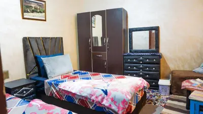 a bedroom with a bed and a dresser and a mirror at Ouarzazate Youth Hostel YHO in Ouarzazate