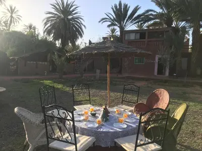 a table with an umbrella in a yard at Bivouac Lot Of Stars in Ouarzazate