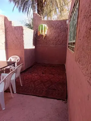 a patio with a table and chairs and a rug at Bivouac Lot Of Stars in Ouarzazate