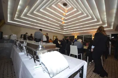 a group of people sitting at tables in a restaurant at Hôtel-Café-Restaurant Pyramides, in Taza