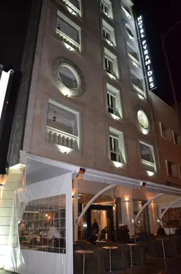 a building with tables and chairs in front of it at Hôtel-Café-Restaurant Pyramides, in Taza