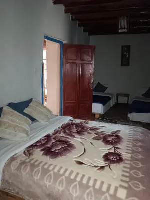 a bed with flowers on it in a room at Relais De Tahla in Ain Boumahdi