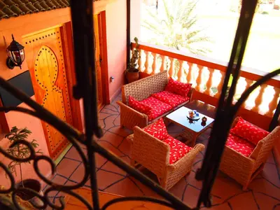 a balcony with chairs and a table on a porch at Riad Al Anwar in Tinerhir