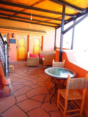 a patio with a table and chairs in a room at Riad Al Anwar in Tinerhir