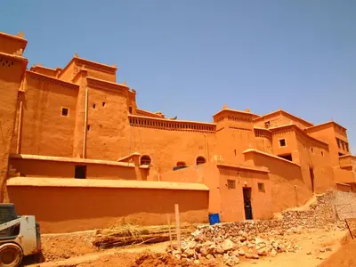 a building in the desert with a truck in front of it at Riad Al Anwar in Tinerhir