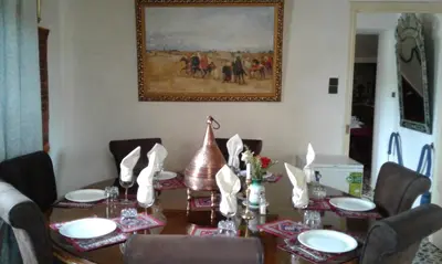 a dining room table with chairs and a wooden table with at Villa Pomme d'Or in Midelt