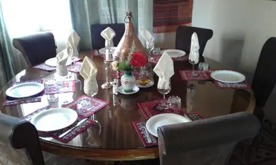 a dining room table with chairs and a wooden table with plates at Villa Pomme d'Or in Midelt