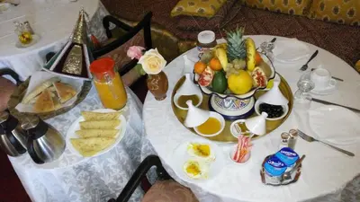 a white table with a plate of fruit on it at Villa Pomme d'Or in Midelt