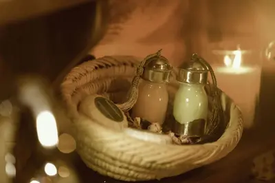 twoented candles in a basket next to a candle holder at Dar Azawad Royal Desert Camp - Erg Chigaga Luxury Glamping in Mhamid