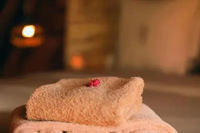 a pink towel with a red flower in it at Dar Azawad Royal Desert Camp - Erg Chigaga Luxury Glamping in Mhamid