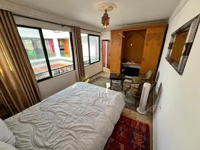 a bedroom with a bed in a room with windows at Fès Riad Scalia Traditional Guesthouse Morocco in Fès