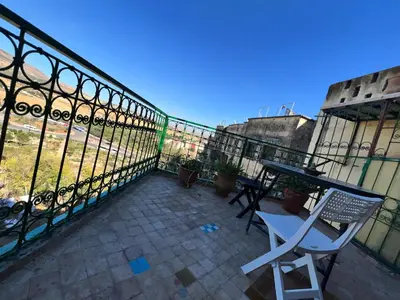 a balcony with a table and a fence at Fès Riad Scalia Traditional Guesthouse Morocco in Fès