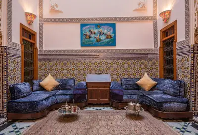 a living room with blue couches and a painting at Fès Riad Scalia Traditional Guesthouse Morocco in Fès