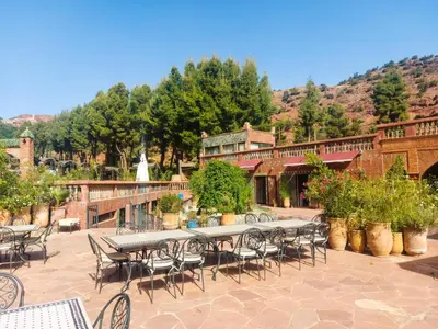 a patio with tables and chairs in front of a building at Aurocher Marrakech Ourika Oukaimeden in Oukkainrdem