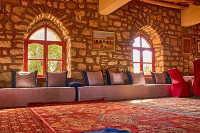 a room with a couch in a stone wall at Auberge Restaurant Telouet in Telouet
