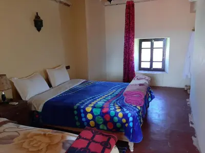 a bedroom with two beds and a window at Auberge Restaurant Telouet in Telouet